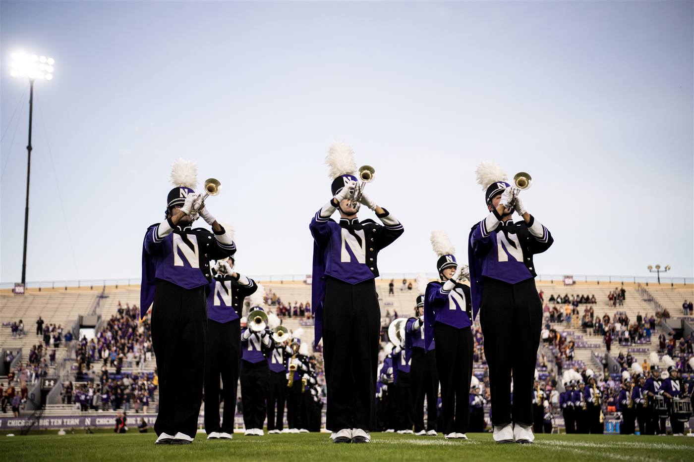 The marching band playing trumpets on the field