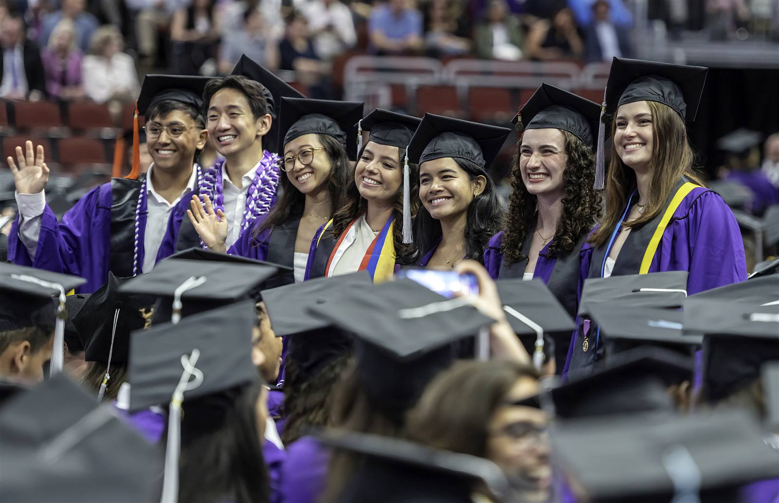 Graduates in purple caps and gowns at commencement