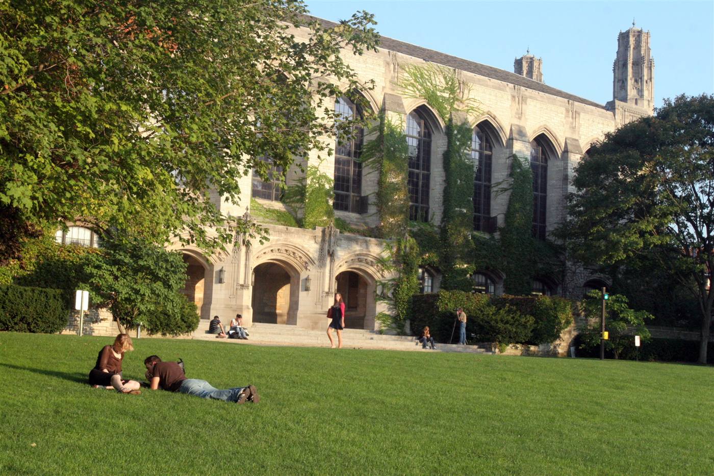 Students relaxing on a lawn in front of Deering Library