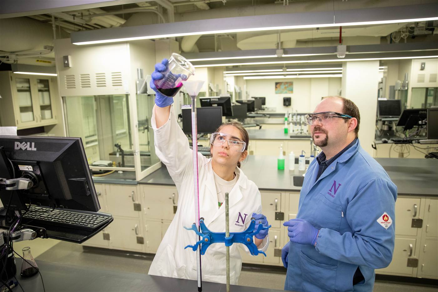 Two researchers working with equipment in a chemistry lab